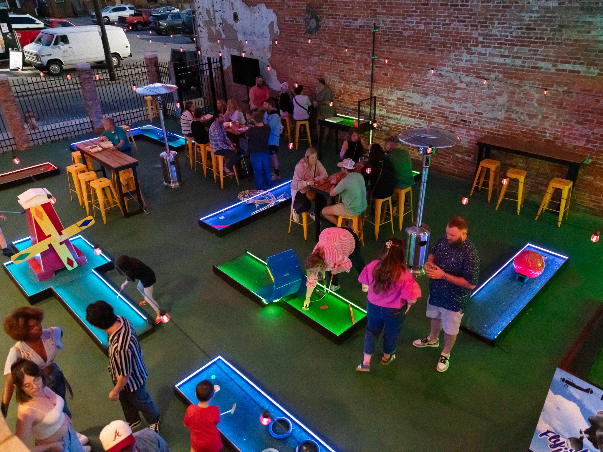 Guests playing Putt and Pour's colorful mini golf course