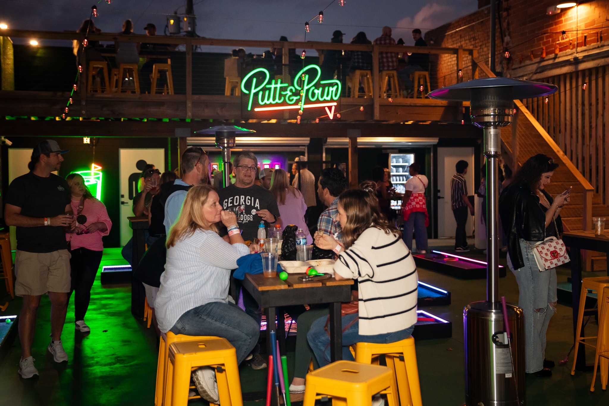 Friends gathering at Putt and Pour at night